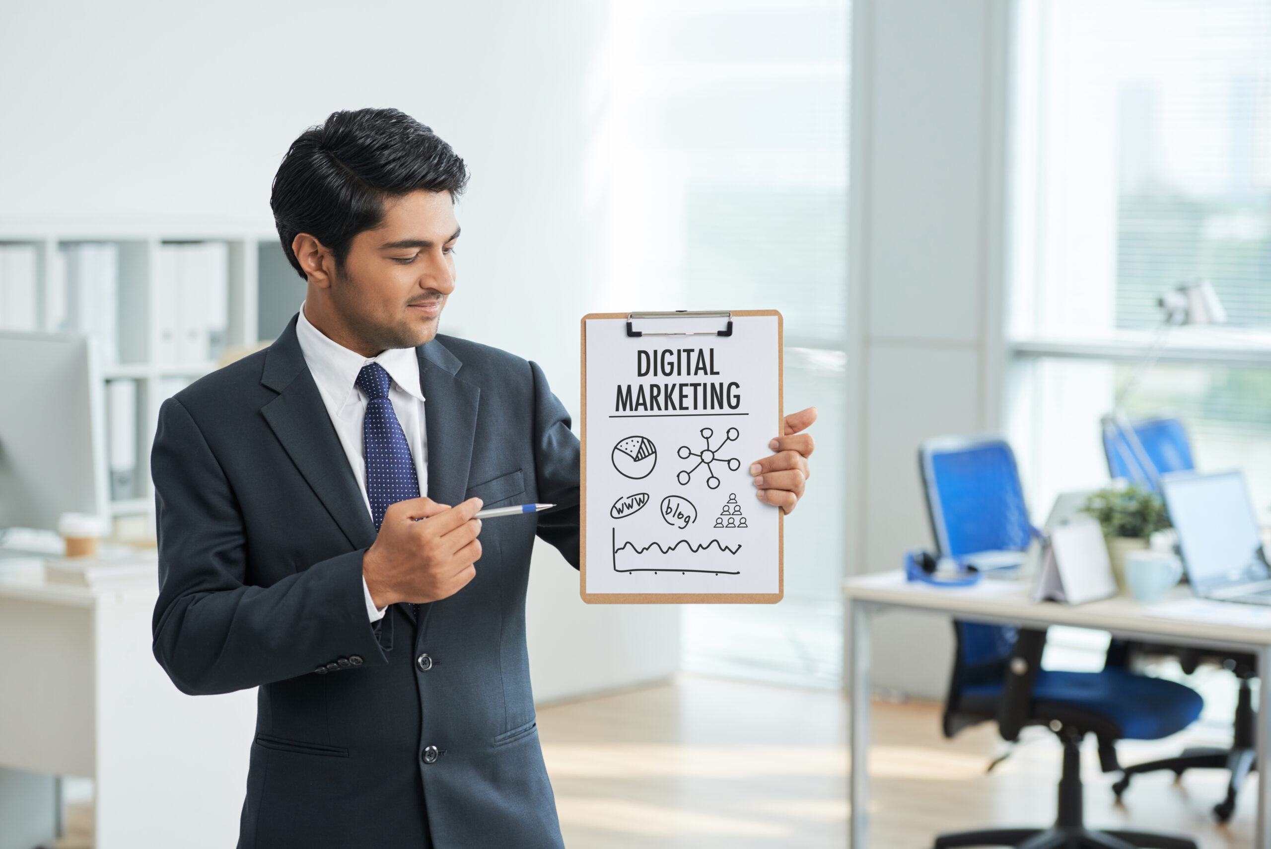Professional presenting a digital marketing concept on a clipboard in a modern office setting.