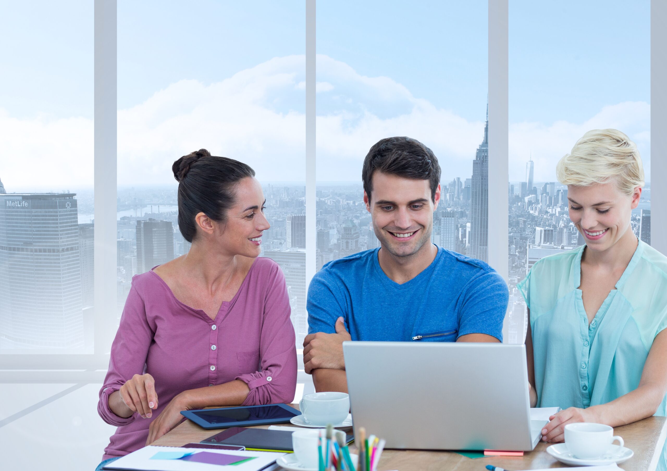 Three professionals discussing hospital administration strategies while working on a laptop in a modern office with a city view.